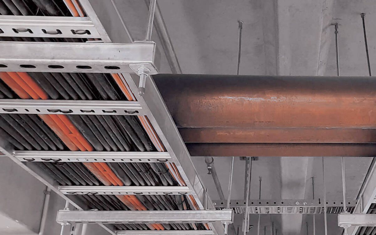 Perforated and ladder cable tray running under a concrete soffit