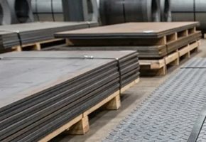 Mild steel plate banded in stacks on pallets in the warehouse